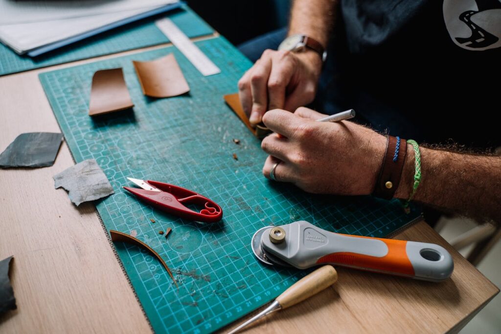 Close-up of a leather artisan crafting on a cutting board in a creative workspace.